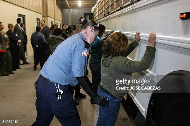 Prison guard frisks a female detainee before embarking onto a bus to be taken to the airport at Willacy Detention facility in Raymondville, Texas on...