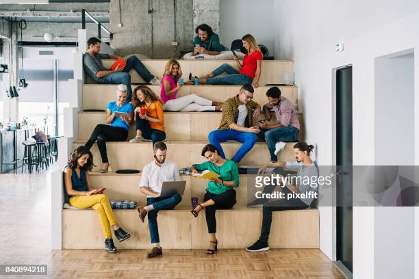 large group of people networking in a loft office - large group of people stock pictures, royalty-free photos & images