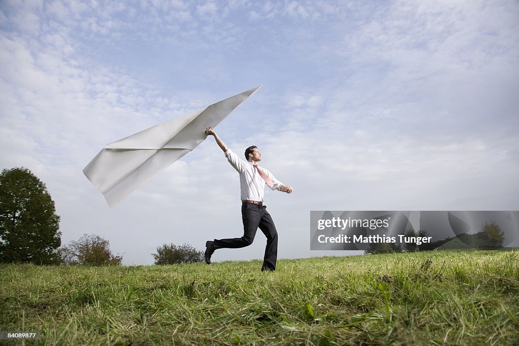 Businessman with giant paper aeroplane