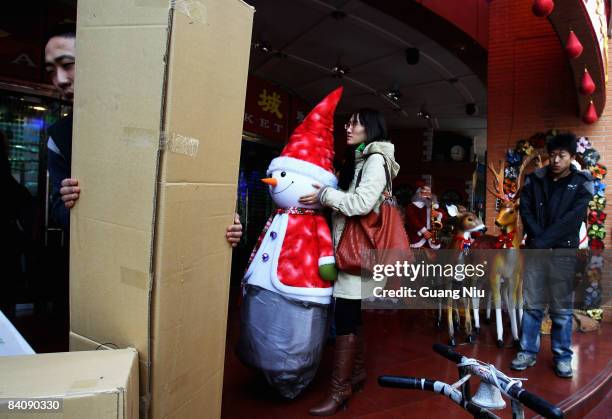 Woman shops for Christmas at a market on December 19, 2008 in Beijing, China. A large number of Christmas decorations destined to the Western market...