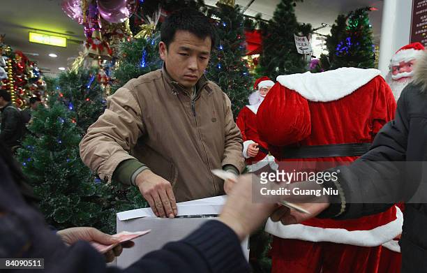 Saleperson looks at a customer buying Christmas decorations at a market on December 19, 2008 in Beijing, China. A large number of Christmas...