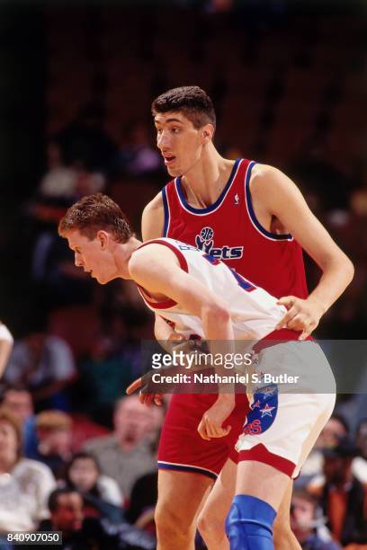 Gheorghe Muresan of the Washington Bullets defends against Shawn Bradley of the Philadelphia 76ers circa 1994 at the Spectrum in Philadelphia,...