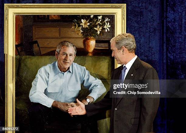 President George W. Bush pretends to shake hands with his official portrait at the National Portrait Gallery December 19, 2008 in Washington, DC. The...