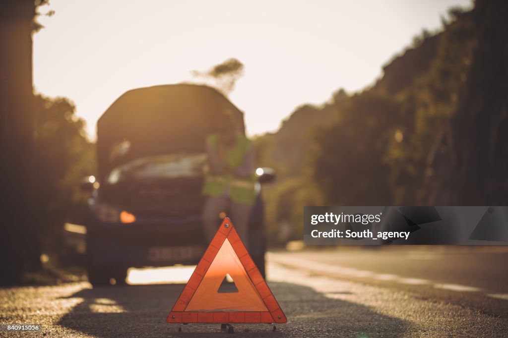 Warning triangle in front of her broken car