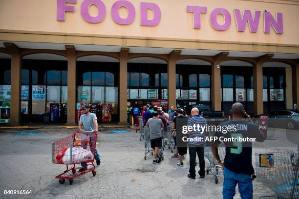 People wait in line to buy groceries at a Food Town during the aftermath of Hurricane Harvey on August 30, 2017 in Houston, Texas. Monster storm...