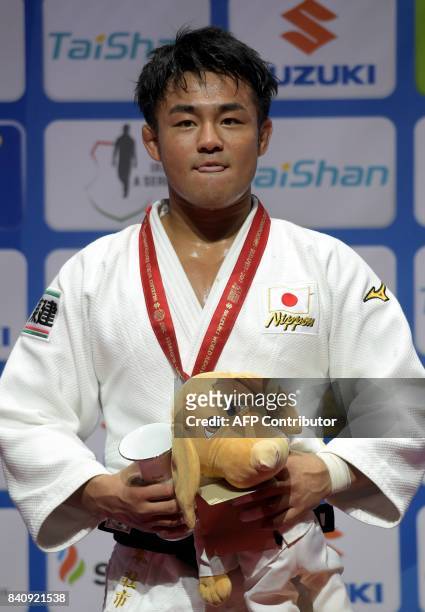 Gold medalist Japan's Soichi Hashimoto celebrates on the podium after his final against Azerbaian's Rustam Orujov in the mens -73kg category at the...