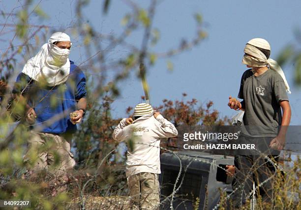 Israeli settlers hold stones ready to throw at journalists and Palestinians near the Jewish settlement of Kharsina, north of the occupied West Bank...