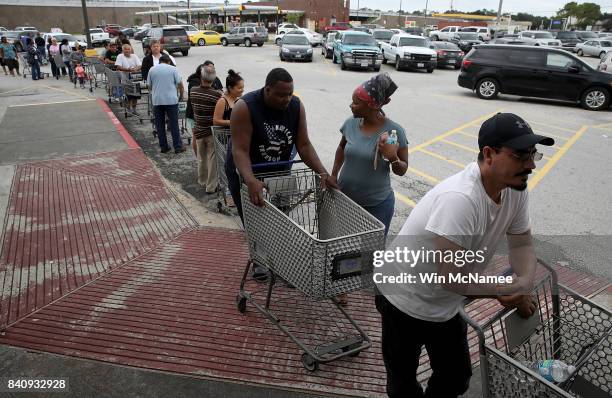 People line up to buy groceries in the Chanelview section of Houston as flood waters began to recede following Hurricane Harvey August 29, 2017 in...