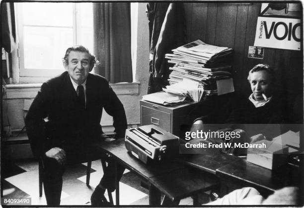 American journalist and Village Voice co-founder and editor Daniel Wolf sits with author Norman Mailer in the Voice's offices in Sheridan Square, New...