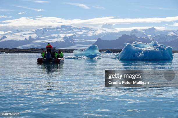 rigid inflatable boat near icebergs in the glacier lagoon of jökulsárlón, iceland - breidamerkurjokull glacier stock pictures, royalty-free photos & images