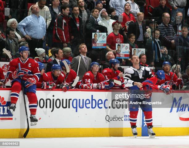 Andrei Markov of the Montreal Canadiens puts his jersey back on after a fight against the Calgary Flames as Saku Koivu of the Montreal Canadiens sits...