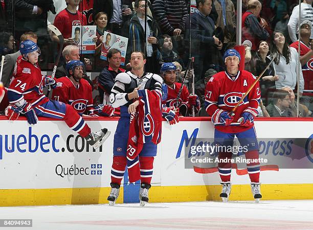 Andrei Markov of the Montreal Canadiens puts his jersey back on after a fight against the Calgary Flames as Alexei Kovalev of the Montreal Canadiens...