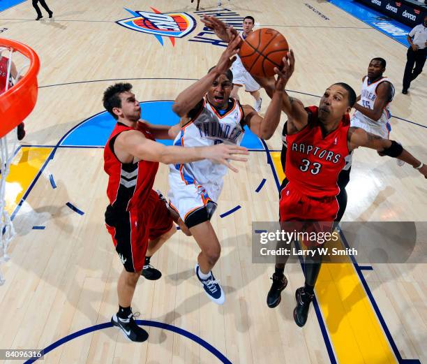 Russell Westbrook of the Oklahoma City Thunder goes to the basket against Andrea Bargnani and Jamario Moon of the Toronto Raptors at the Ford Center...