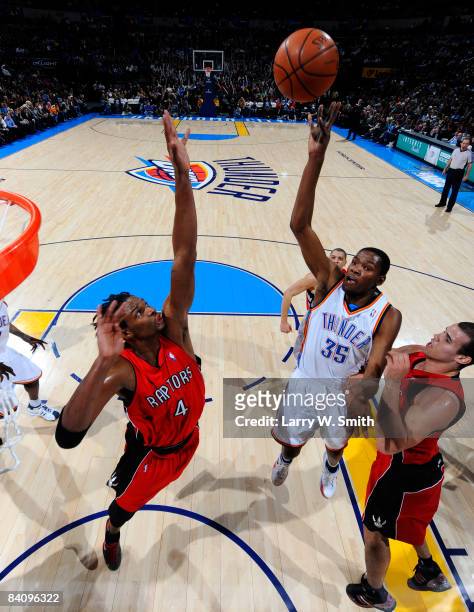 Kevin Durant of the Oklahoma City Thunder goes to the basket against Chris Bosh and Chris Humphries of the Toronto Raptors at the Ford Center on...