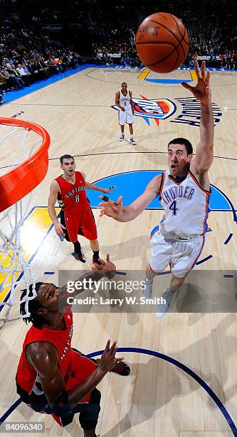 Nick Collison of the Oklahoma City Thunder goes to the basket against Chris Bosh of the Toronto Raptors at the Ford Center on December 19, 2008 in...