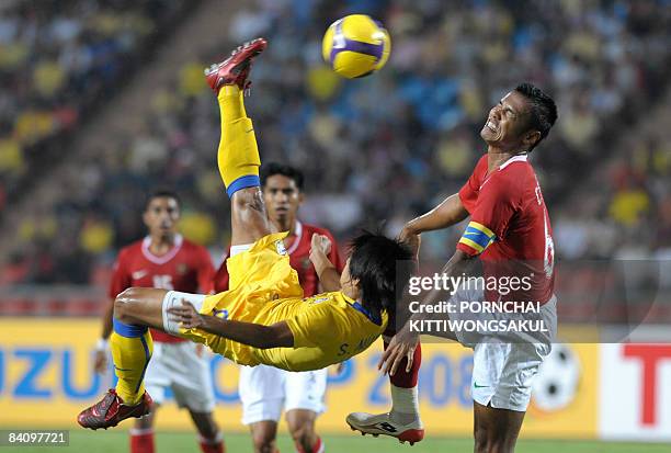 Thai football player Suchao Nutnum over-head kicks the ball next to Charis Yulianto of Indonesia during their AFF Suzuki Cup 2008 at Rajamangala...