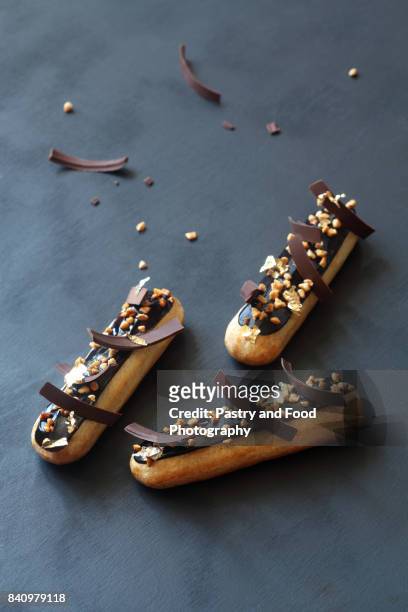 chocolate eclairs with calamelized nuts - relámpago de crema fotografías e imágenes de stock