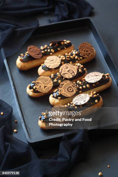 chocolate eclairs with calamelized nuts - eclair au chocolat bildbanksfoton och bilder