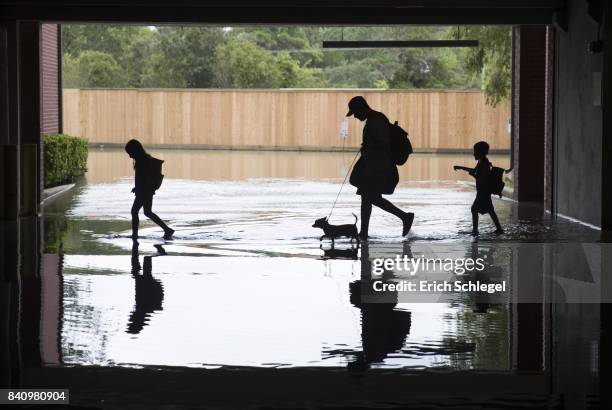 The Martinez family evacuates the apartment complex they live in near the Energy Corridor of west Houston, Texas where high water coming from the...