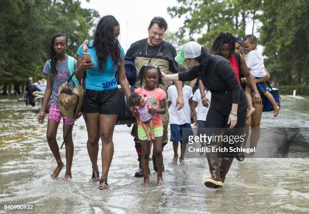 The Walker and Brown families walk out of the water at Memorial Drive and North Eldridge Parkway in the Energy Corridor of west Houston, Texas where...