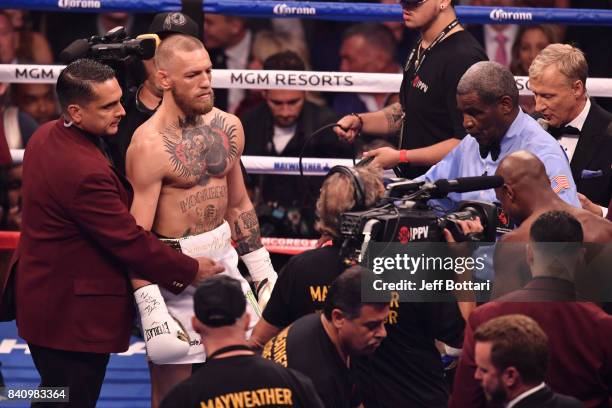 Referee Robert Byrd giving instructions to Floyd Mayweather Jr. And Conor McGregor before their super welterweight boxing match on August 26, 2017 at...