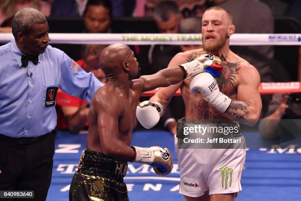 Floyd Mayweather Jr. Pushes Conor McGregor after the bell rings in their super welterweight boxing match at T-Mobile Arena on August 26, 2017 in Las...