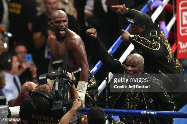 Floyd Mayweather Jr. And Floyd Mayweather Sr. Celebrate after defeating Conor McGregor in their super welterweight boxing match at T-Mobile Arena on...