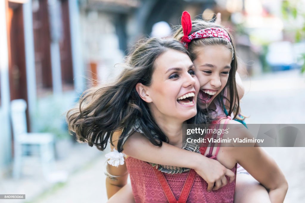 Mother and daughter having fun on street