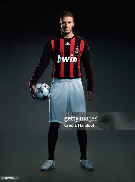 In this handout photo provided by adidas, David Beckham of AC Milan reveals his new number 32 shirt before a press conference to announce the start...