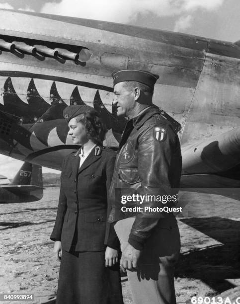 American military commander Maj Gen Claire L Chennault stands with an unidentified American Red Cross volunteer in front of a North American P-51...