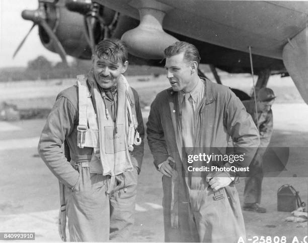 American actor and US Army Air Corps gunner Capt Clark Gable and co-pilot Lt Col Robert W Burns, both of the USAAC Boeing B-17 'The Duchess,' discuss...