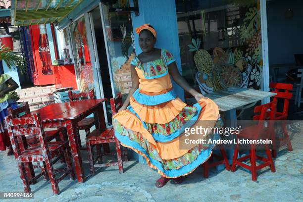 Waitress displays a traditional dress from the larger Afro-Caribbean community on August 16, 2017 in the coastal city of Cartagena, Columbia. After...