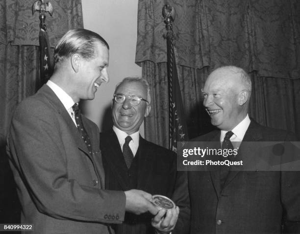 Prince Philip, Duke of Edinburgh shares a laugh with US President Dwight Eisenhower as he is presented with the National Geographic Society's Gold...