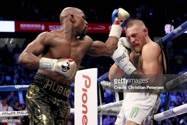 Floyd Mayweather Jr. Throws a punch at Conor McGregor during their super welterweight boxing match on August 26, 2017 at T-Mobile Arena in Las Vegas,...
