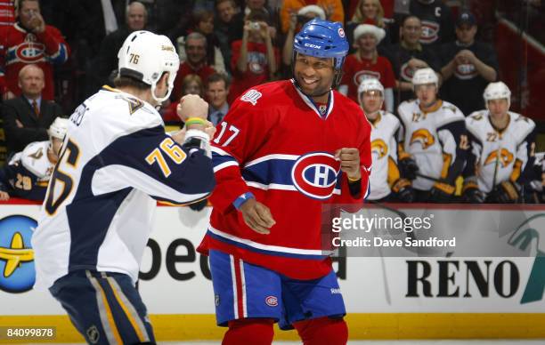 Georges Laraque of the Montreal Canadiens smiles as he fights Andrew Peters of the Buffalo Sabres during their NHL game at the Bell Centre December...