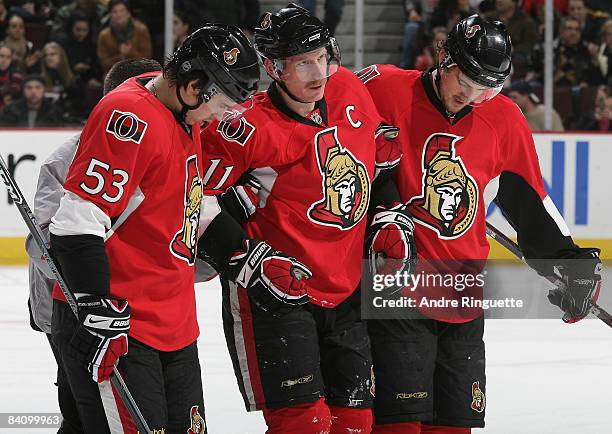 Daniel Alfredsson of the Ottawa Senators is helped off the ice after being injured by Ilya Zubov and Nick Foligno of the Ottawa Senators in an NHL...