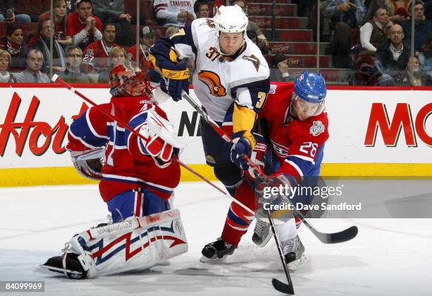 Matt Ellis of the Buffalo Sabres interferes with Jaroslav Halak of the Montreal Canadiens as he tries to get a stick on the puck while Josh Gorges of...