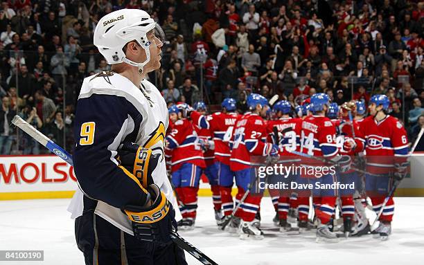 Derek Roy of the Buffalo Sabres skates off the ice as the Montreal Canadiens celebrate their overtime victory during their NHL game at the Bell...