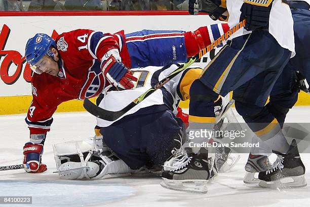 Tomas Plekanec of the Montreal Canadiens is sent flying overtop of Ryan Miller of the Buffalo Sabres during their NHL game at the Bell Centre...