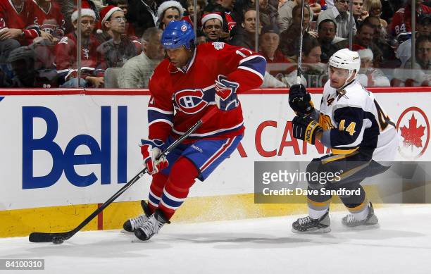 Andrej Sekera of the Buffalo Sabres defendsa against Georges Laraque of the Montreal Canadiens during their NHL game at the Bell Centre December 20,...