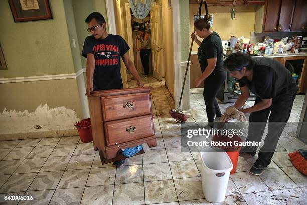 Juan Figueroa removes damaged furniture from his mother's Northeast Houston home where residents begin rebuilding from the destruction of Hurricane...