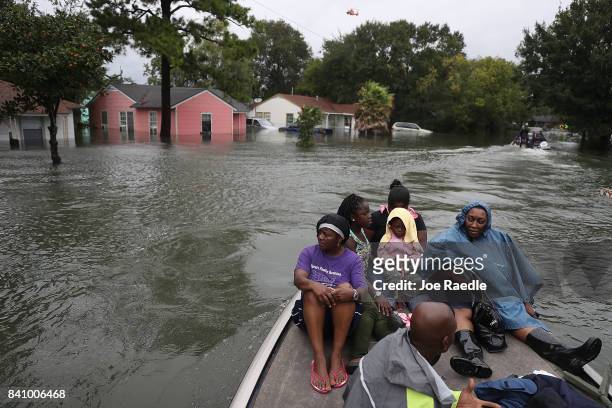 Evacuees sit on a boat after being rescued from flooding from Hurricane Harvey on August 30, 2017 in Port Arthur, Texas. Harvey, which made landfall...