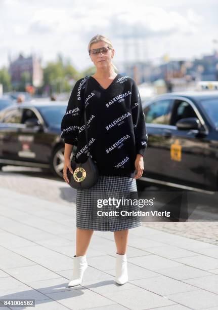 Janka Polliani wearing black Balenciaga sweater, Loewe bag, checked skirt outside Whyred on August 30, 2017 in Stockholm, Sweden.