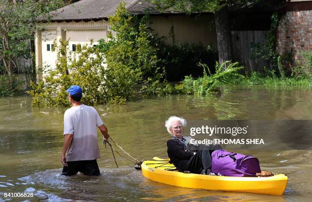 Woman is evacuated on a canoe as people escape flood waters in Lakeside Estate in Houston, Texas on August 30, 2017. - Monster storm Harvey made...