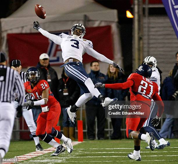 Michael Reed of the Brigham Young University Cougars can't come up with a reception as Trevin Wade and Corey Hall of the Arizona Wildcats defend...