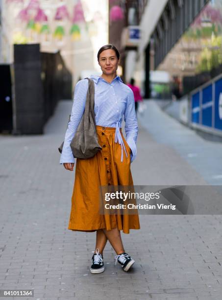 Guest wearing a white bluse blouse, midi skirt, Vans outside Busnel on August 30, 2017 in Stockholm, Sweden.