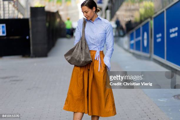 Guest wearing a white bluse blouse, midi skirt, Vans outside Busnel on August 30, 2017 in Stockholm, Sweden.