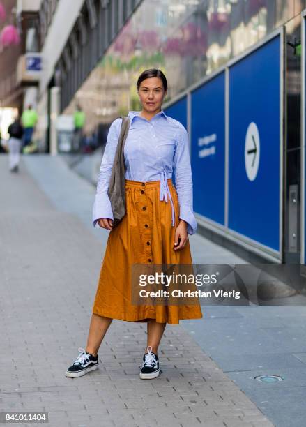 Guest wearing a white bluse blouse, midi skirt, Vans outside Busnel on August 30, 2017 in Stockholm, Sweden.