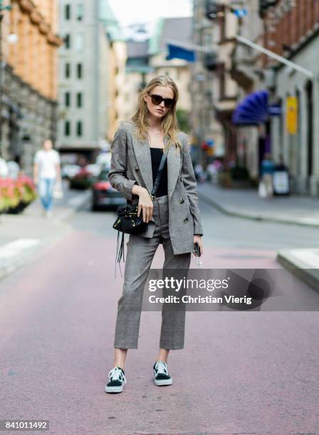 Model Emma Stalhammar wearing a Balenciaga bag, grey suit outside Busnel on August 30, 2017 in Stockholm, Sweden.