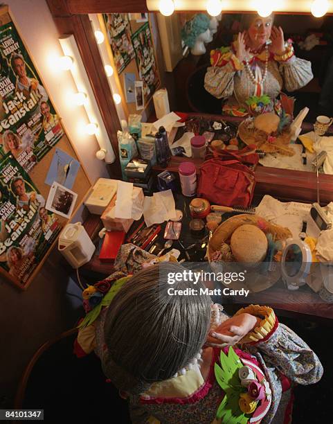 Chris Harris applies the finishing touches to his make-up in his dressing room backstage as he prepares for his role as Dame Trott in the production...